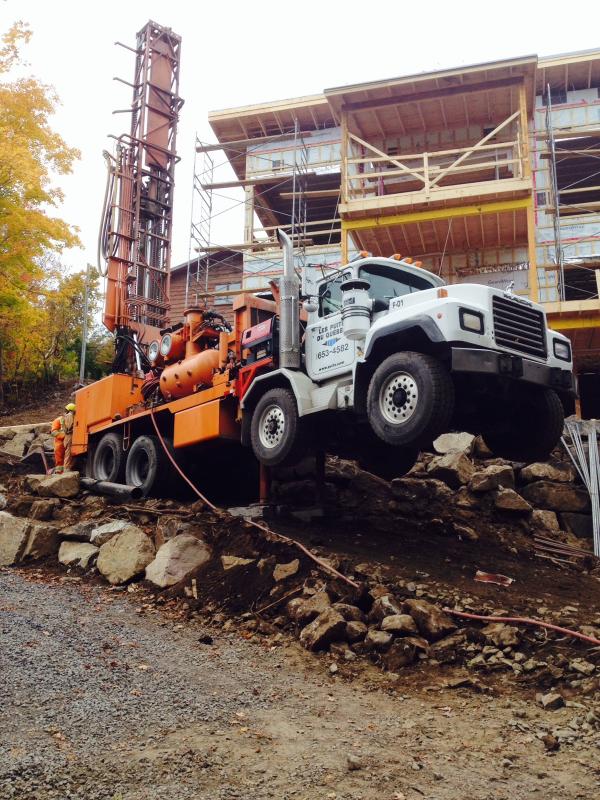 Main tendant un verre d’eau claire symbolisant un puits artésien  à Sept-Îles.