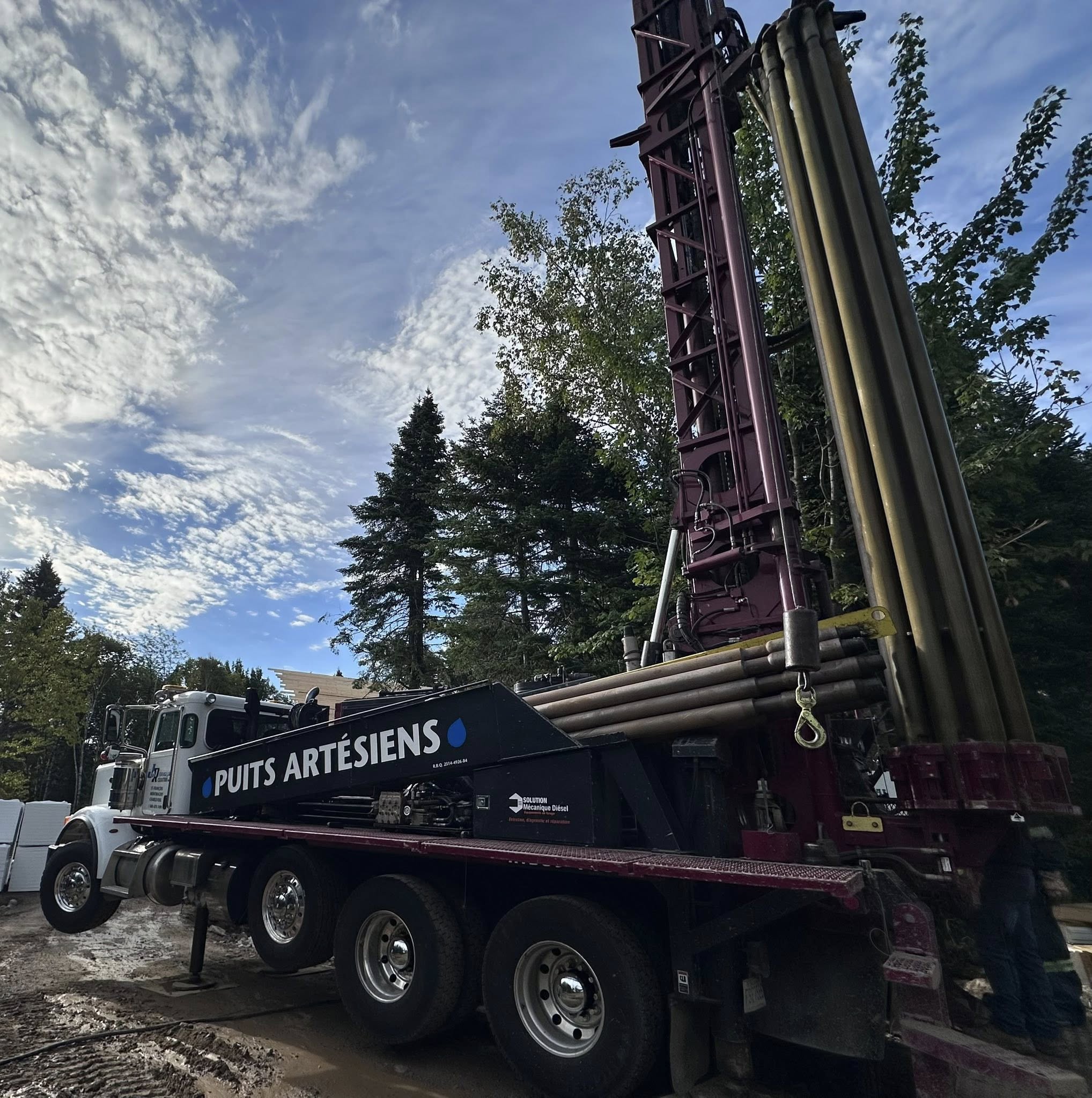 Main tendant un verre d’eau claire symbolisant un puits artésien  dans Charlevoix.